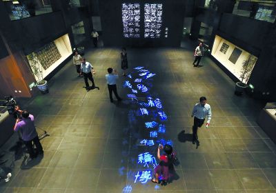 昨天，在國(guó)家典籍博物館內(nèi)，通過(guò)藝術(shù)投影技術(shù)呈現(xiàn)在展廳地面上的“漢字歷史長(zhǎng)河”，引得參觀者駐足觀看。
