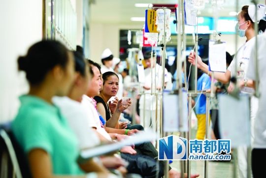 醫(yī)院走道坐滿了打吊針的員工。