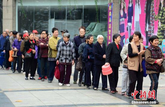 圖為10月28日，在江西九江市一家羊絨皮草服裝服飾博覽會現(xiàn)場，老人們正在頂著寒風(fēng)排隊等待領(lǐng)取10元代金劵。