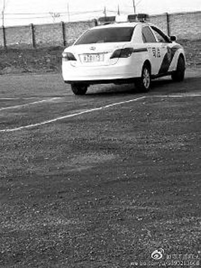 一輛車牌號 為“ 陜DD173”的制式警車停在一個劃著白線的場地上，車身標有“司法”字樣