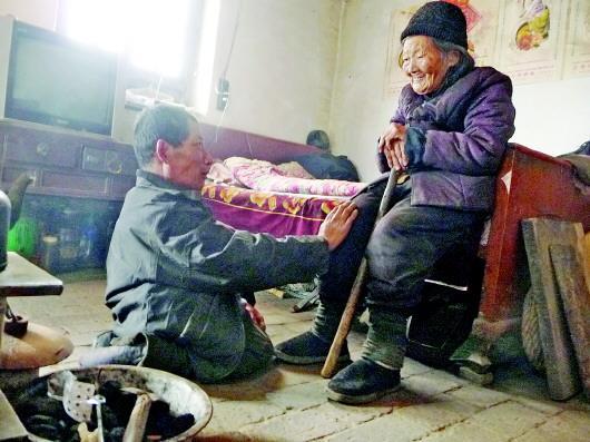 52歲的劉蘭山每天靠爬行照顧90歲的老母親。孫國祥 攝