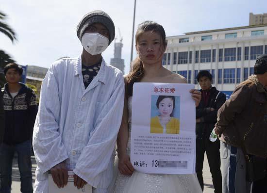 昆明火車站廣場上，24歲的黃習菊身穿潔白的婚紗，帶著身患白血病的弟弟征婚。