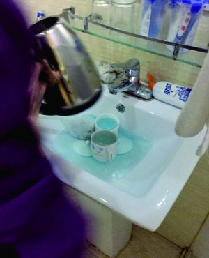 酒店服務(wù)員用潔廁液刷燒水壺和茶杯。