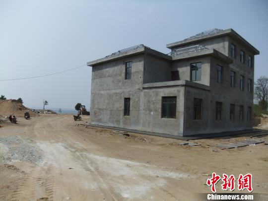 鴨河水庫庫區(qū)邊的新建別墅，一面墻上寫著“拆”，另一邊在加緊施工。吳揚　攝
