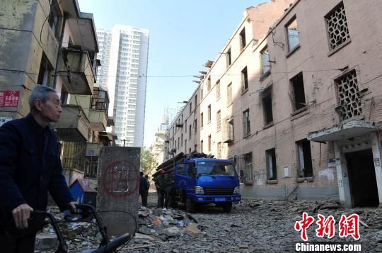 一位花甲老人站在即將拆除的樓房旁，默默地與“蘇聯(lián)樓”告別。　翟羽佳　攝