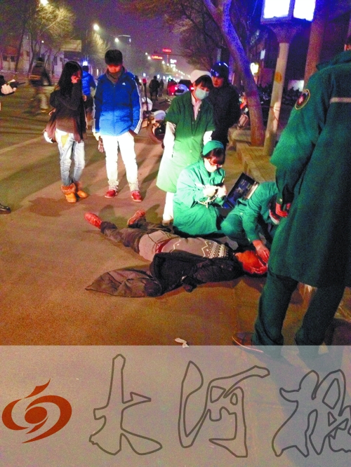 醉漢躺在地上，醫(yī)護(hù)人員對其進(jìn)行檢查。